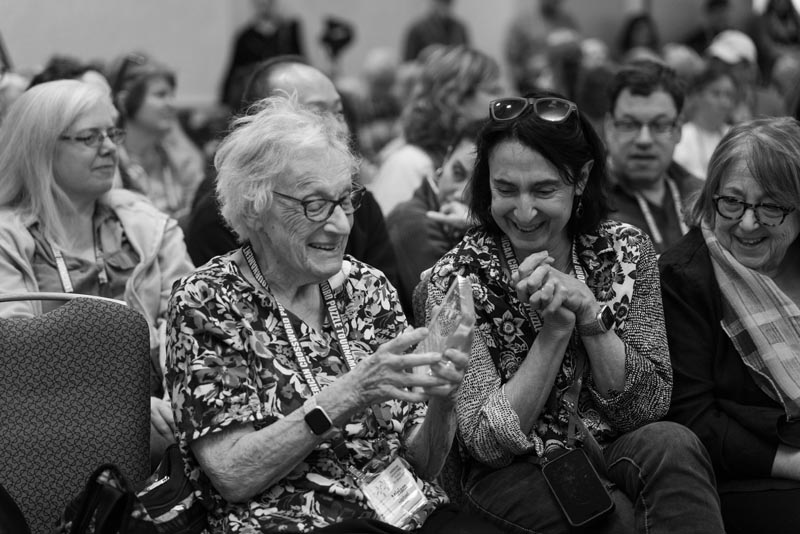 Miriam Raphael admires her Centenarian award, with daughter Ruth and Evie Eysenburg
